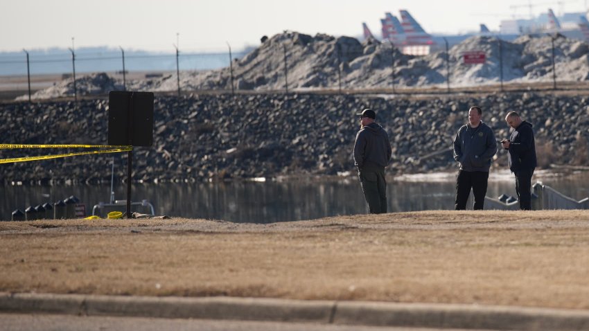 People look out towards the crash site of the American Airlines plane on the Potomac River as it approached the Reagan National Airport on January 30, 2025 in Arlington, Virginia.