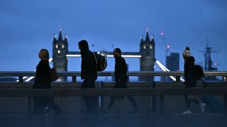 Commuters cross London Bridge, with Tower Bridge behind, early in the morning of January 24, 2025.