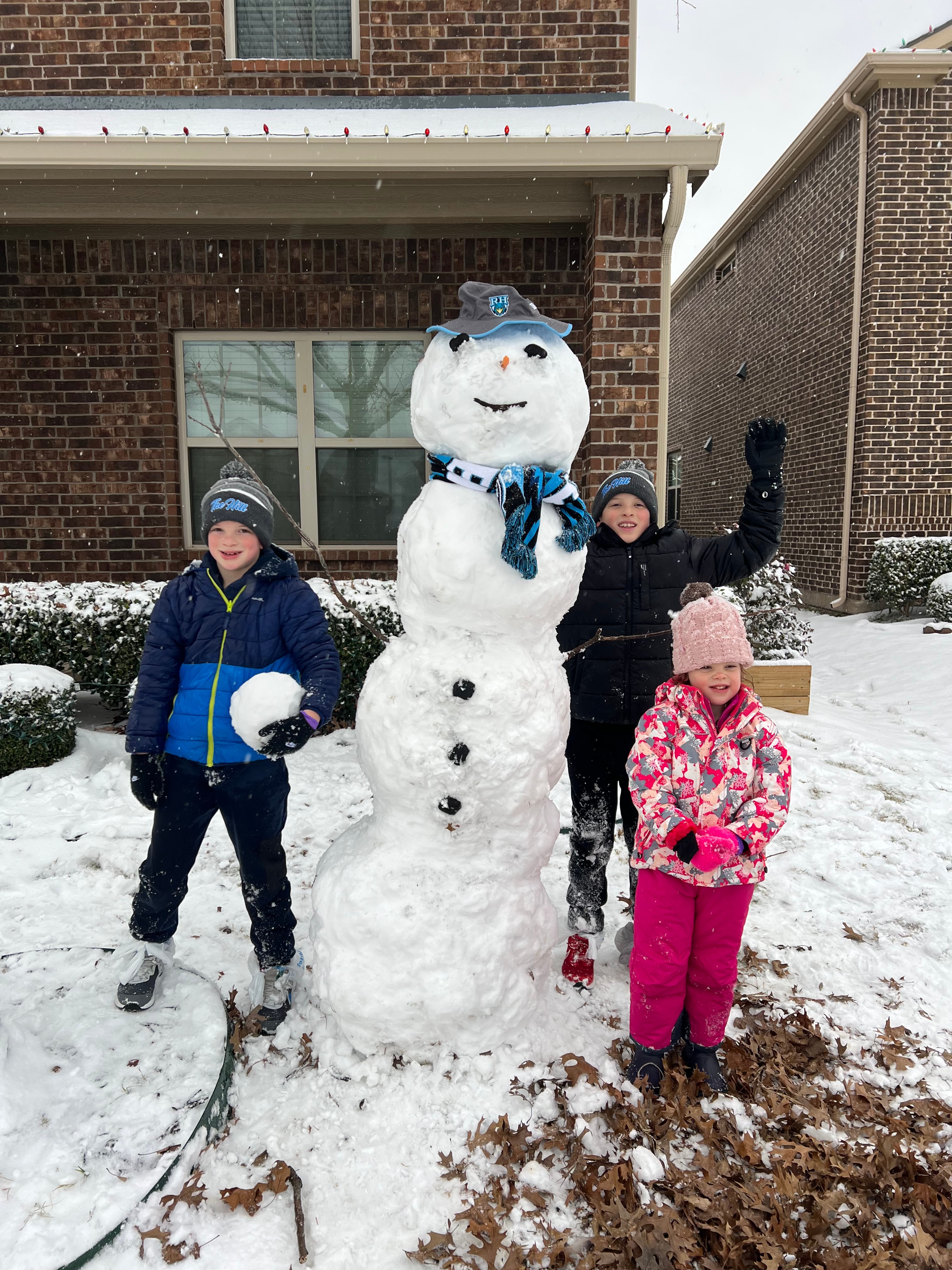 My grandkids in Prosper Tx. Fun morning building a snowman in Rockhill Highschool attire