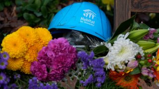 A Habitat for Humanity hard hat is among the items left in tribute to former President Jimmy Carter at the entrance to the Jimmy Carter Presidential Center Tuesday, Dec. 31, 2024, in Atlanta. Carter died Sunday at the age of 100.