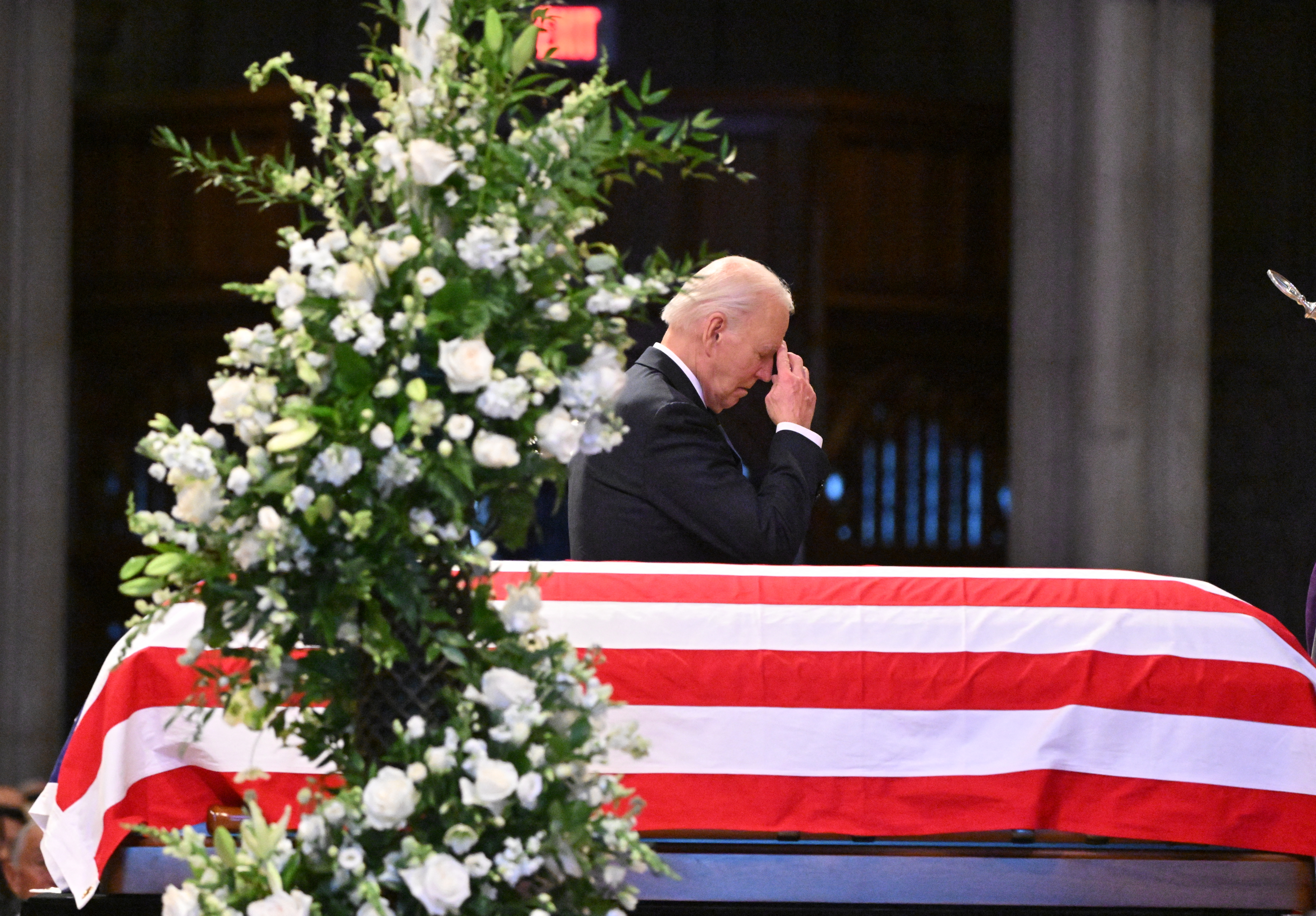 US President Joe Biden makes the sign of the cross as he walks past the casket of former US President Jimmy Carter during his State Funeral Service at the Washington National Cathedral in Washington, DC, on January 9, 2025.