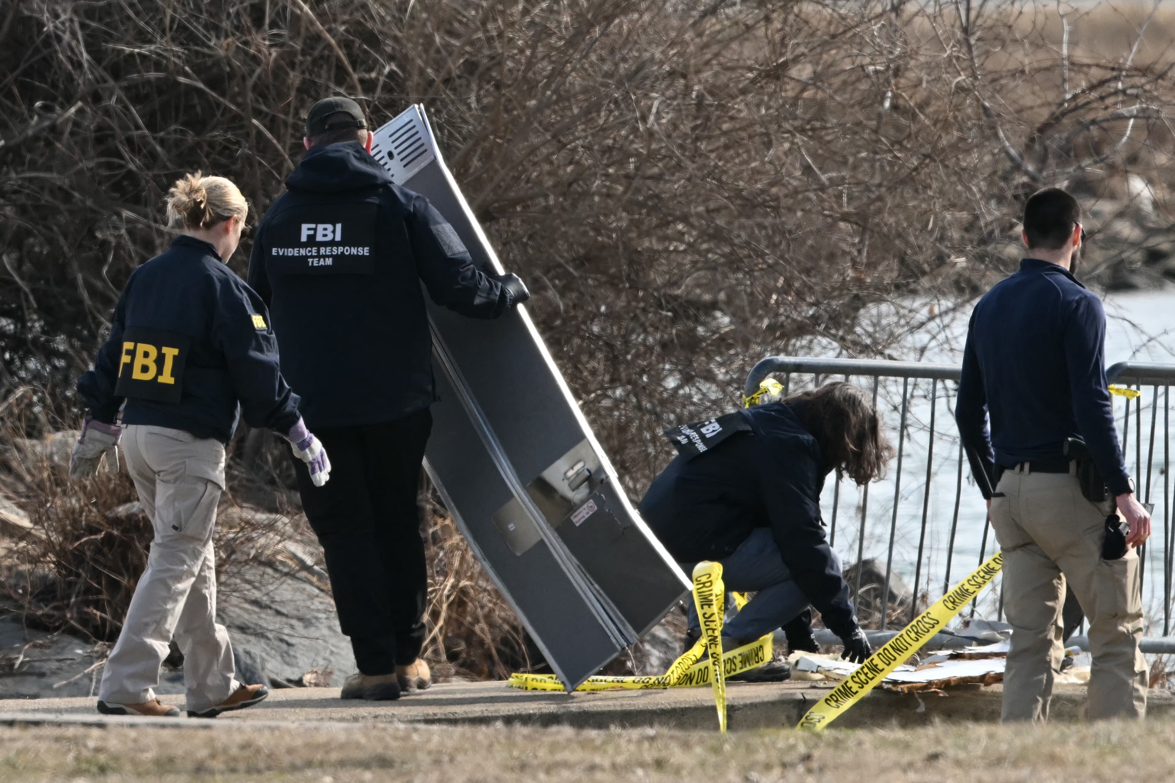 Investigators gather pieces of wreckage along the Potomac River after the crash, on Jan. 30, 2025.