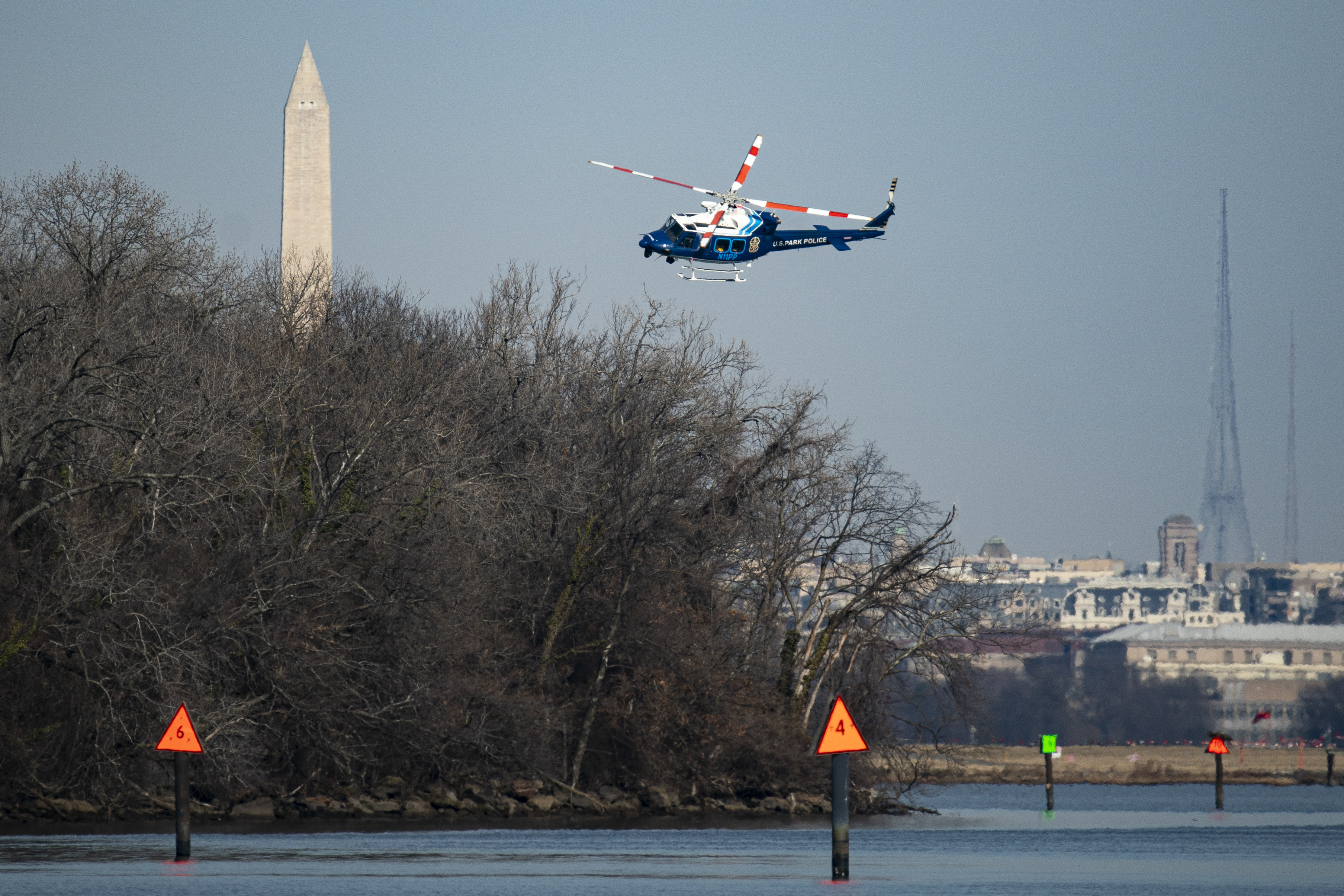 A U.S. Park Police helicopter flies near the crash site on Jan. 30, 2025.