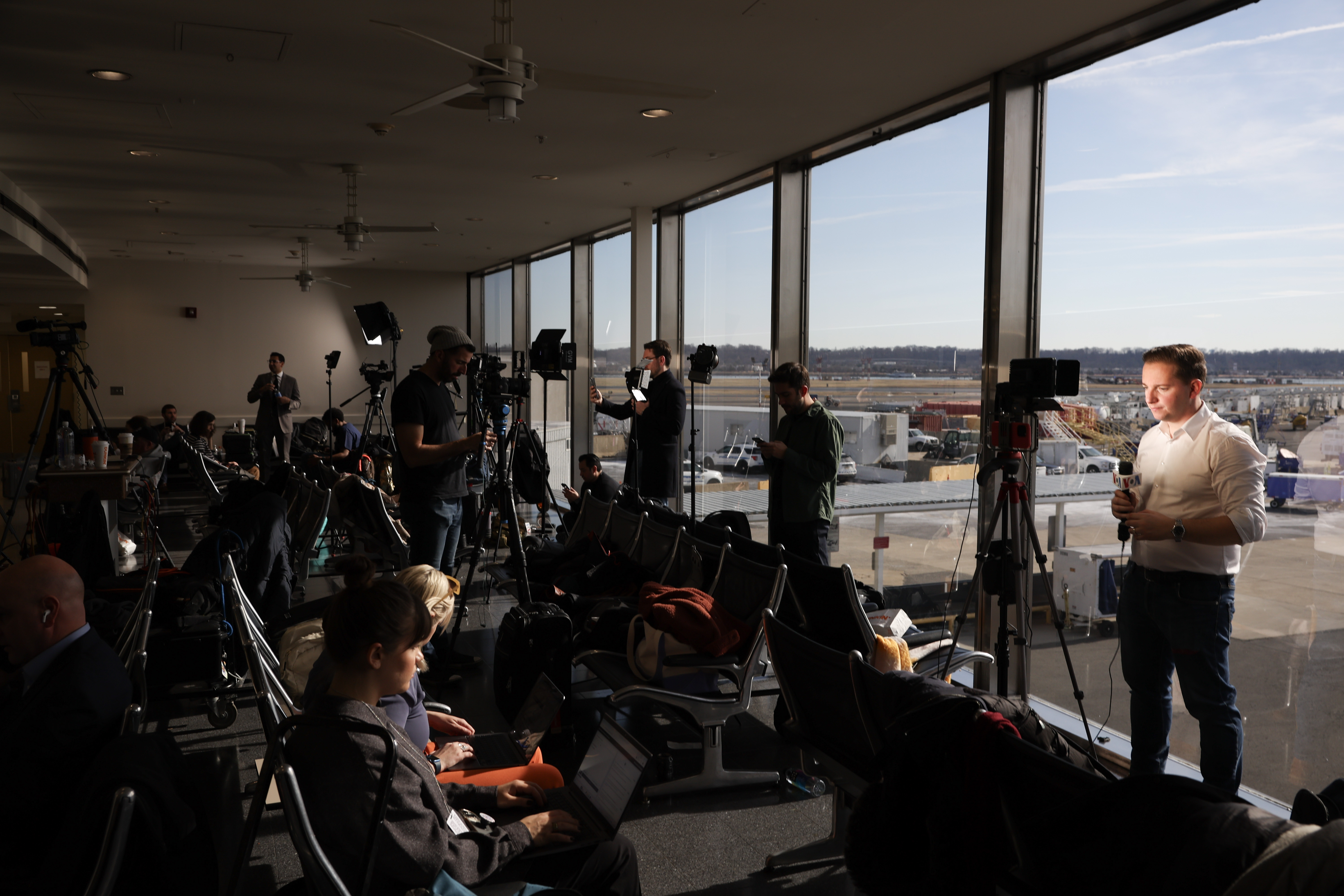 Members of the media work at Reagan National Airport, as the crash investigation continues, on Jan. 30, 2025.