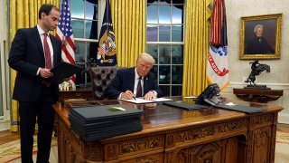 President Donald Trump signs an executive order withdrawing the U.S. from the World Health Organization in the Oval Office of the White House, Monday, Jan. 20, 2025, in Washington.