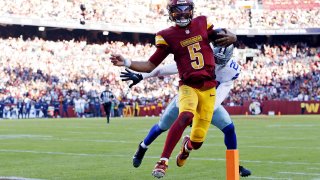 Nov 24, 2024; Landover, Maryland, USA; Washington Commanders quarterback Jayden Daniels (5) runs for a touchdown against Dallas Cowboys safety Malik Hooker (28) during the third quarter at Northwest Stadium.