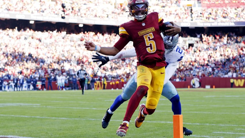 Nov 24, 2024; Landover, Maryland, USA; Washington Commanders quarterback Jayden Daniels (5) runs for a touchdown against Dallas Cowboys safety Malik Hooker (28) during the third quarter at Northwest Stadium.