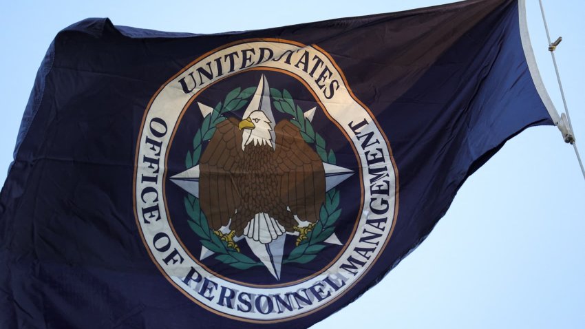 An organizational flag flies outside of the Office of Personnel Management in Washington, D.C. on February 7, 2025 as demonstrators gather to protest federal layoffs and demand the termination of Elon Musk from the Department of Government Efficiency (DOGE). 