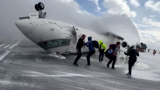 Passengers leave a Delta Air Lines CRJ-900 jet after it crashed on landing at Toronto Pearson International Airport in Mississauga, Ontario, Canada Feb. 17, 2025 in a still image from video. 