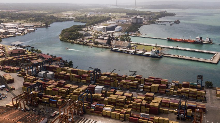 Cargo containers sit stacked as cranes load and unload containers