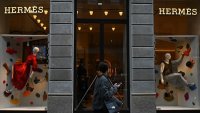 A woman walks past a Hermes boutique in Via Monte Napoleone, a famous upscale shopping street in Milan.