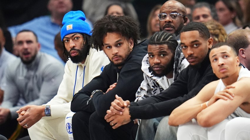 Dallas Mavericks players, from left, Anthony Davis, Dereck Lively II, Jaden Hardy, and P.J. Washington wear street clothes as they watch the first half of an NBA basketball game against the Phoenix Suns Sunday, March 9, 2025, in Dallas. (AP Photo/Julio Cortez)