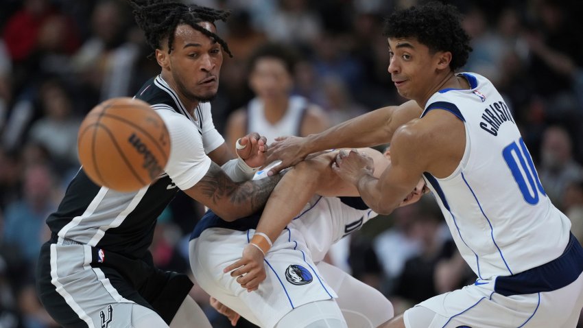 San Antonio Spurs guard Stephon Castle, left, and Dallas Mavericks guard Max Christie, right, scramble for a loose ball during the second half of an NBA basketball game in San Antonio, Monday, March 10, 2025.