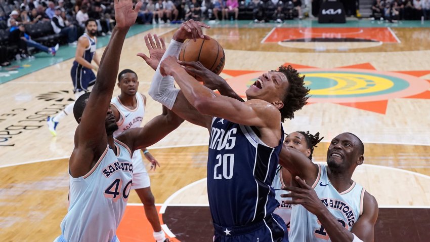 Dallas Mavericks forward Kessler Edwards (20) is blocked by San Antonio Spurs forward Harrison Barnes (40) as he drives to the basket during the first half of an NBA basketball game in San Antonio, Wednesday, March 12, 2025.