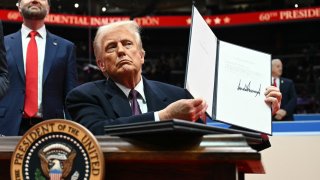 US President Donald Trump holds letter to the UN stating the US withdrawal from the Paris Agreement during the inaugural parade inside Capital One Arena, in Washington, DC, on January 20, 2025.
