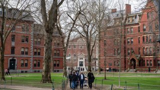 People walk through Harvard Yard on the Harvard University campus in Cambridge, Massachussetts, on April 15, 2025.