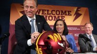Washington Commanders managing partner Josh Harris (L) signs a Commanders helmet while joined by  Washington DC Mayor Muriel Bowser (C) and NFL Commissioner Roger Goodell (R) during a news conference on construction of a new Commanders stadium on April 28, 2025 in Washington, DC.