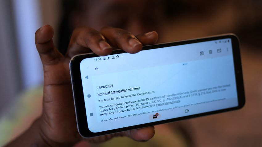 Haitian immigrant Nicole, who works for a meat processing plant, shows an email terminating her parole, Sunday, April 13, 2025, in Dumas, Texas. (AP Photo/Eric Gay)