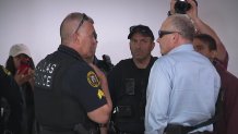 Jeff Metcalf, right, talks with Dallas police at the NGAN offices in Dallas, Texas, Thursday, April 17, 2025.