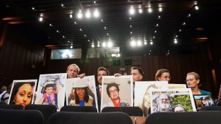 Family members hold photographs of crash victims lost in two deadly Boeing 737 Max crashes that killed 346 people as Boeing CEO Dennis Muilenburg testifies before a Senate Commerce, Science and Transportation Committee hearing on aviation safety and the grounded 737 Max, on Capitol Hill in Washington, Oct. 29, 2019.