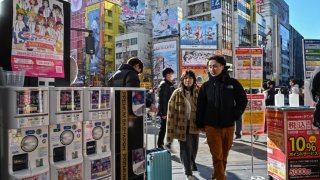 TOPSHOT – Customers enter an electronics shop in the Akihabara district of Tokyo on January 12, 2024.
