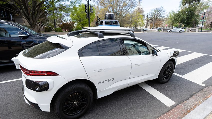 A Waymo self-driving car, seen with a driver, stops at a red light outside the U.S. Capitol in Washington, D.C., on Friday, March 31, 2025.