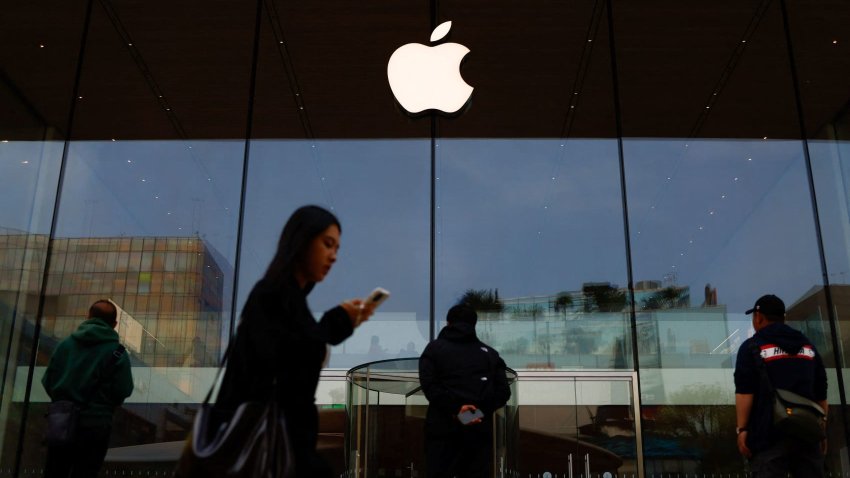 People stand in front of an Apple store in Beijing, China, on April 9, 2025.