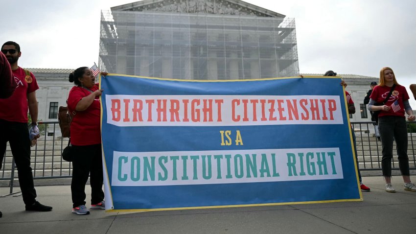 People hold a sign as they participate in a protest outside the US Supreme Court over President Donald Trump’s move to end birthright citizenship as the court hears arguments over the order in Washington, DC, on May 15, 2025.
