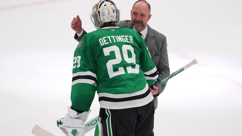 Dallas Stars goaltender Jake Oettinger (29) and head coach Pete DeBoer, rear, celebrate the teams 4-2 win against the Colorado Avalanche in Game 7 of a first-round NHL hockey playoff series Saturday, May 3, 2025, in Dallas. (AP Photo/Julio Cortez)