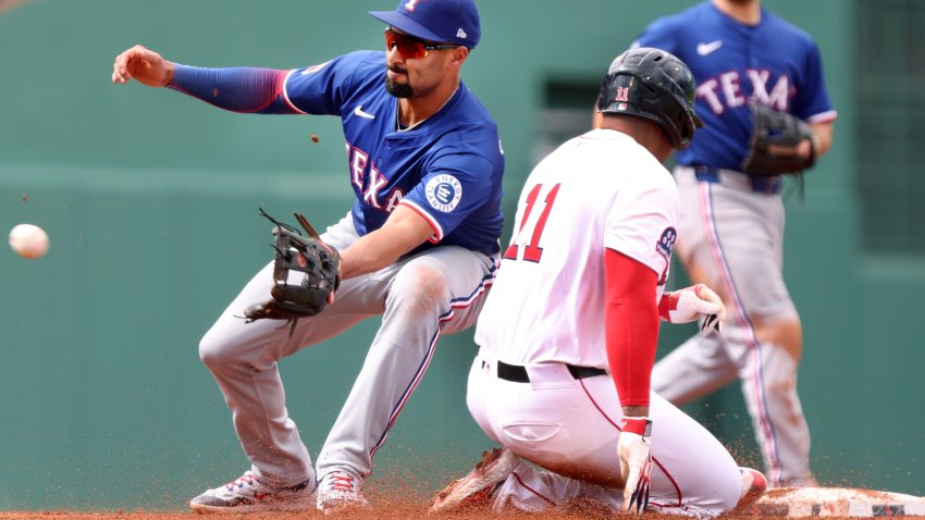 Boston Red Sox’s Rafael Devers (11) beats the throw to Texas Rangers second baseman Marcus Semien as he steals second base in the fifth inning of a baseball game, Thursday, May 8, 2025, in Boston. (AP Photo/Jim Davis)