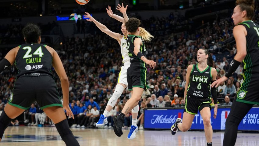 Dallas Wings guard Paige Bueckers (5), back, passes around Minnesota Lynx guard Natisha Hiedeman (2) during the first half of a WNBA basketball game Wednesday, May 21, 2025, in Minneapolis. (AP Photo/Abbie Parr)