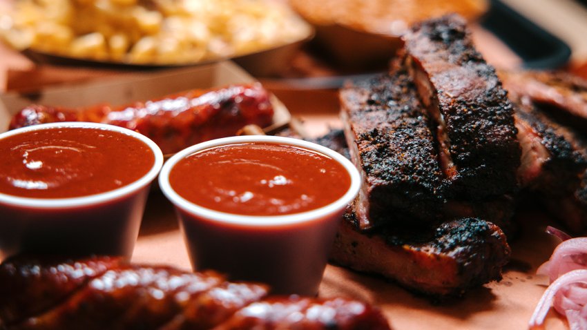 Large servings of Texas barbecue, with pork ribs, sausage, macaroni and cheese, and baked beans.