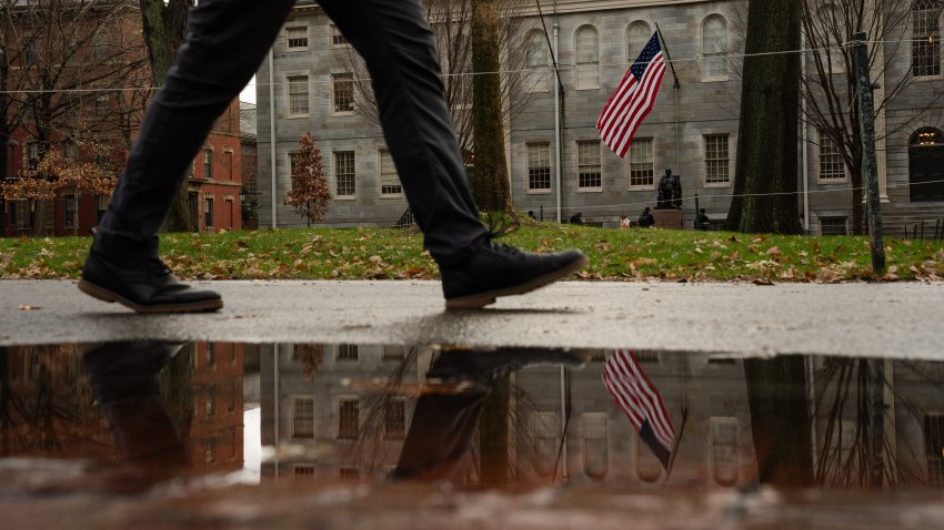 A file photo of an American flag hanging near a statue of John Harvard at Harvard University in Cambridge, Massachusetts.
