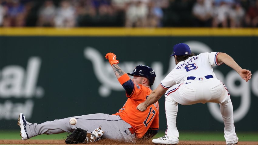 ARLINGTON, TEXAS – MAY 15: Victor Caratini #17 of the Houston Astros slides past Josh Smith #8 of the Texas Rangers on his double during the second inning at Globe Life Field on May 15, 2025 in Arlington, Texas.