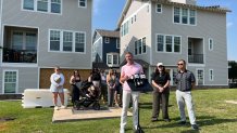 Dallas City councilman Chad West speaks during the press conference with residents of the townhomes standing behind him.