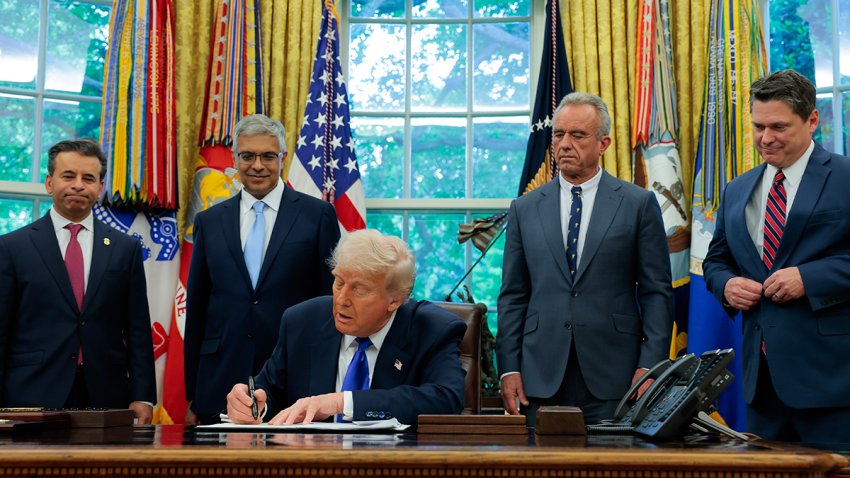 President Donald Trump, accompanied by Food and Drug Administration Commissioner Marty Makary (L), National Institutes of Health Director Jayanta Bhattacharya (2nd-L), Health and Human Services Secretary Robert F. Kennedy Jr. (2nd-R) and Domestic Policy Council Director Vince Haley (R), signs an executive order in the Oval Office at the White House on May 5, 2025.
