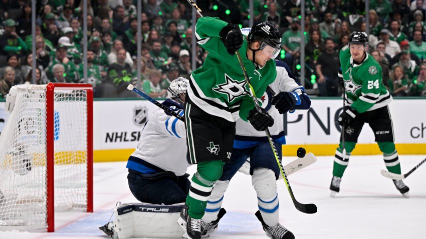 May 11, 2025; Dallas, Texas, USA; Dallas Stars center Mikael Granlund (64) attempts to redirect the puck past Winnipeg Jets goaltender Connor Hellebuyck (37) during the second period in game three of the second round of the 2025 Stanley Cup Playoffs at American Airlines Center. Mandatory Credit: Jerome Miron-Imagn Images