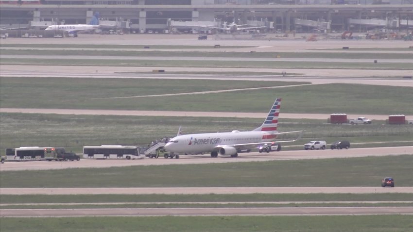 Passengers get back on an American Airlines flight stopped for a possible security issue on Wednesday, May 14, 2025, at Dallas-Fort Worth International Airport.