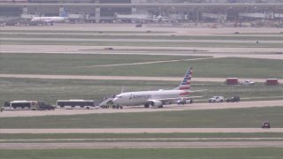 Passengers get back on an American Airlines flight stopped for a possible security issue on Wednesday, May 14, 2025, at Dallas-Fort Worth International Airport.