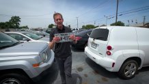 NBC 5 senior investigative reporter Scott Friedman with a metal license plate.
