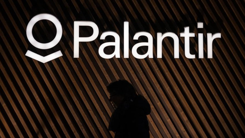 A woman walking past the logo of U.S. big data analytics software company Palantir Technologies during the World Economic Forum annual meeting in Davos, Switzerland.