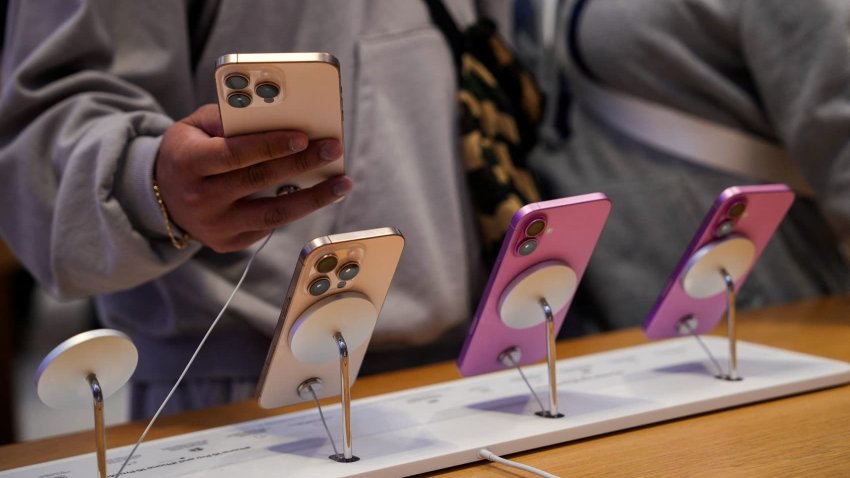 People look at iPhones at the Apple Fifth Avenue store in New York City, U.S., May 23, 2025.