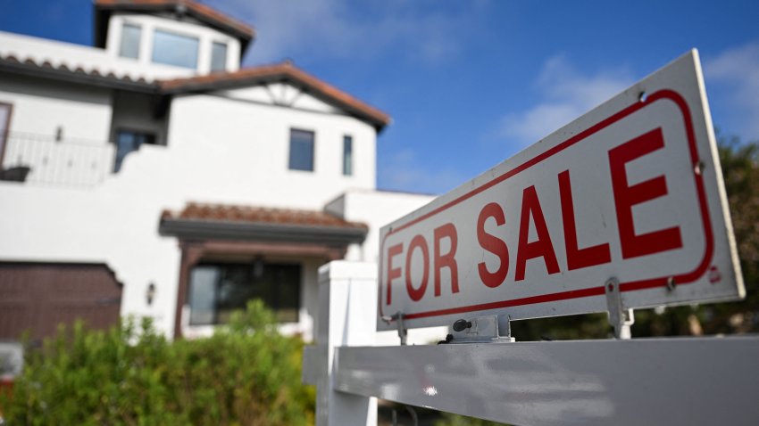A "for sale" sign is displayed outside of a home