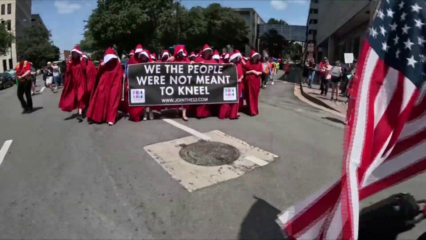 Group of women dressed as handmaidens at ‘No Kings' protest in Fort Worth