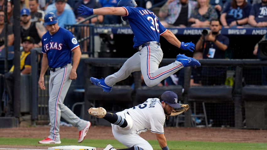 Texas Rangers’ Wyatt Langford (36) leaps over Tampa Bay Rays first baseman Jonathan Aranda as he reaches first base safely on a throwing error by Jose Caballero during the first inning of a baseball game Wednesday, June 4, 2025, in Tampa, Fla. (AP Photo/Chris O’Meara)