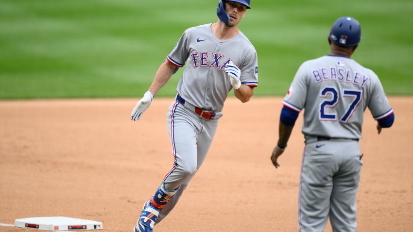 Texas Rangers’ Evan Carter, left, rounds the bases on his two-run home run next to third base coach Tony Beasley (27) during the second inning of a baseball game against the Washington Nationals, Sunday, June 8, 2025, in Washington. (AP Photo/Nick Wass)