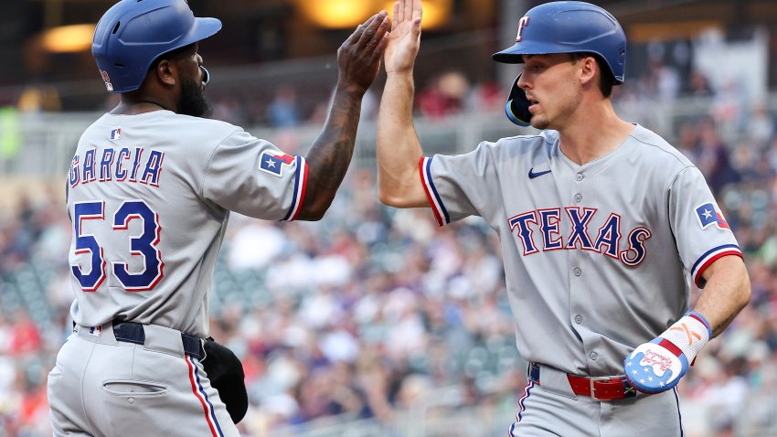 Texas Rangers’ Adolis García, left, and Evan Carter celebrate after scoring on a single hit by Kyle Higashioka during the fourth inning of baseball game against the Minnesota Twins, Tuesday, June 10, 2025, in Minneapolis. (AP Photo/Matt Krohn)