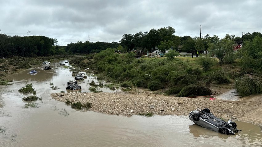 Vehicles sit in the river after being swept away by floodwaters in San Antonio, Tx., Thursday, June 12, 2025. (AP Photo/Lekan Oyekanmi)