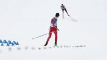 Norway's Jens Luraas Oftebro checks behind him before crossing the finish to win gold