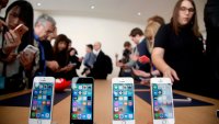 In this March 21, 2016, file photo members of the media and invited guests take a look at the new iPhone SE during an event at Apple headquarters in Cupertino, Calif.